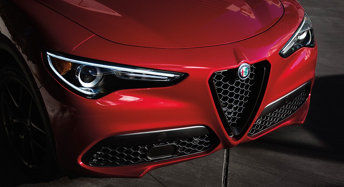 Close up of a red Stelvio's front grille and lights