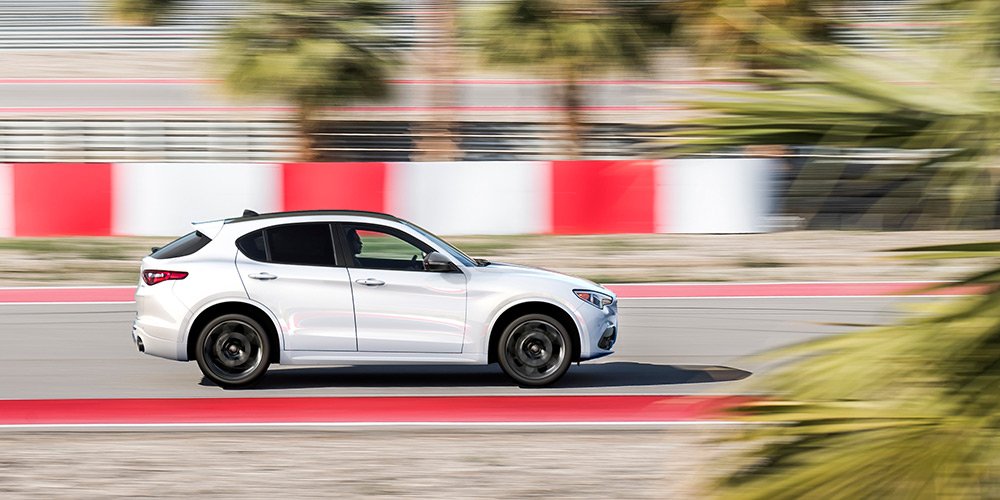 Side view of a white Stelvio driving